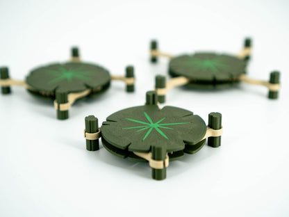 Set of green leaf-shaped coasters with gold accents on a white background