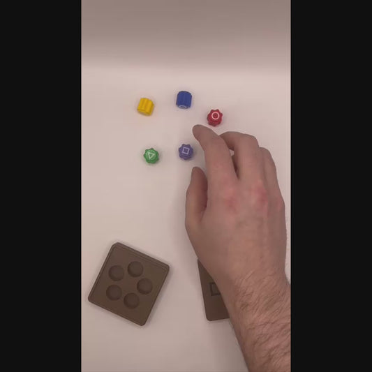 Catching weighted gonggi dice on the back of the hand, with the twist-lock case on the table